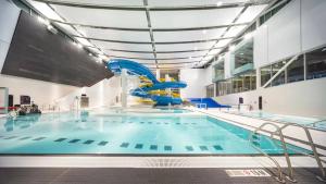 a large swimming pool with a blue water slide at TNC Stays Luxurious Modern Suite Seton Calgary South in Calgary