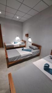 a room with two beds with blue towels on them at Holabay Surf Hostel in Arugam Bay