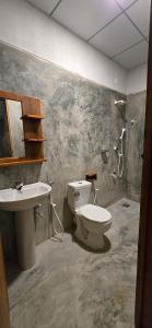 a bathroom with a toilet and a sink at Holabay Surf Hostel in Arugam Bay