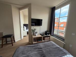 a bedroom with a bed and a large window at Harbour Stay Volendam in Volendam