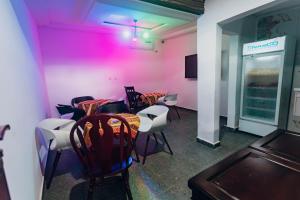 ein Esszimmer mit Tisch und Stühlen und rosa Wänden in der Unterkunft La clémentine in Jacqueville
