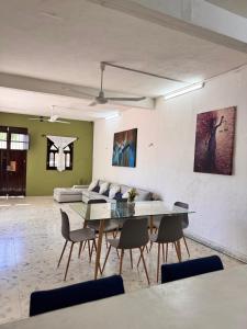 a living room with a table and a couch at Casa verde El Platanar con Jardín Tropical Calkiní in Calkiní