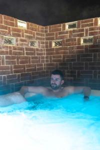 a man is laying in a swimming pool at El Nido wellness a spa in Vysoké Mýto