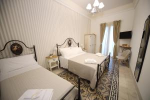 a hotel room with two beds and a chair at Sinfonia Barocca in Modica