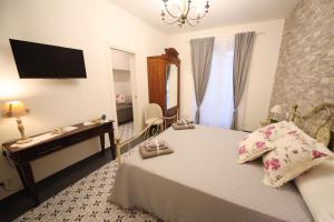 a bedroom with a bed and a desk and a television at Sinfonia Barocca in Modica
