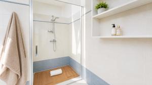 a bathroom with a shower with a wooden floor at Sunrise Apartment by Symphonya Luxury Holiday Rentals in Otranto +10 photos
