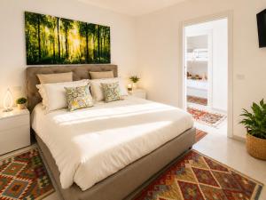 a large bed in a bedroom with a painting on the wall at Sunrise Apartment by Symphonya Luxury Holiday Rentals in Otranto
