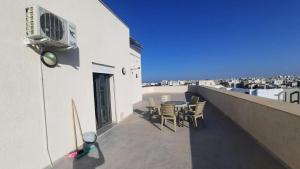 a balcony with a table and chairs on a building at Fantastic appartement in Hammam Sousse