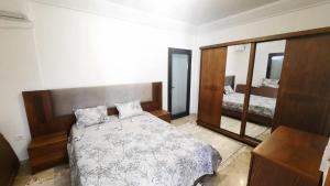 a bedroom with a bed and a large mirror at Fantastic appartement in Hammam Sousse