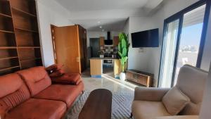 a living room with a brown couch and a kitchen at Fantastic appartement in Hammam Sousse