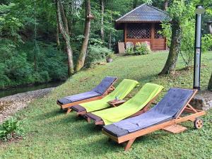 a group of lawn chairs and a gazebo at Kuća za odmor uz rijeku Slapnica, u Parku prirode Žumberak, finska sauna i jacuzzi in Krašić