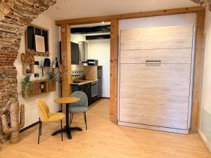 a sliding door in a kitchen with a table and chairs at Studio LA PETITE PAUSE in Ajaccio