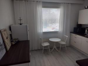 a kitchen with a table and two chairs and a window at Gran Palmu in Pori