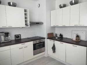 a white kitchen with white cabinets and a stove at Gran Palmu in Pori
