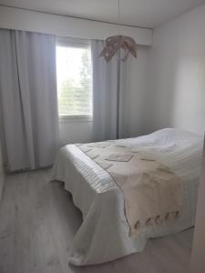 a bedroom with a white bed with a window at Gran Palmu in Pori