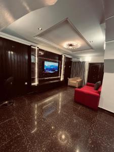 a living room with a red couch and a flat screen tv at Seyi Homes in Hausa