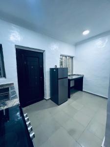 a kitchen with a black door and a black refrigerator at Seyi Homes in Hausa +14 photos