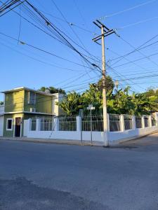 a white fence in front of a house at Casa verde El Platanar con Jardín Tropical Calkiní in Calkiní