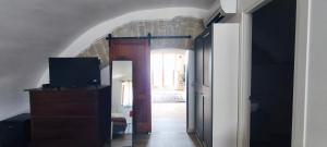 a hallway with a door to a room with a tv at Guesthouse Acherusia in Bacoli