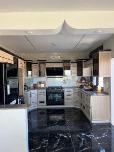 a kitchen with white cabinets and black marble counter tops at زهرة الخليج in Jerash