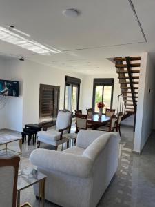 a living room with a couch and a table and chairs at زهرة الخليج in Jerash
