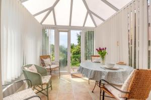 a conservatory with a table and chairs and a glass ceiling at 2 Bed in Richards Castle oc-r45225 in Lane to Richards Castle