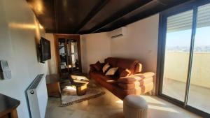 a living room with a couch and a large window at Elegant appartement in Hammam Sousse