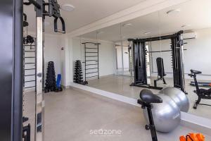 a fitness room with a mirror and a gym at Modern studio in a condominium with pool MSU0701 in Governador Valadares