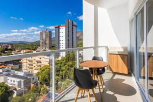 a balcony with a table and chairs and a view at Modern studio in a condominium with pool MSU0701 in Governador Valadares