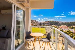 a balcony with a table and chairs and a view at Modern studio in a condominium with pool MSU0701 in Governador Valadares +1 photo
