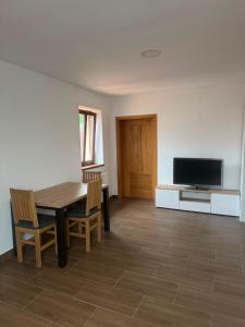 a dining room with a table and a television at Apartmán Netolice in Netolice