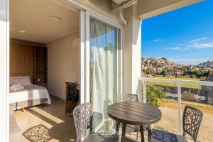 a bedroom with a table and a balcony with a view at Studio in a cond. w/gym in the city center MSU0301 in Governador Valadares