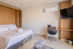 a bedroom with a bed and a desk and a television at Studio in a cond. w/gym in the city center MSU0301 in Governador Valadares