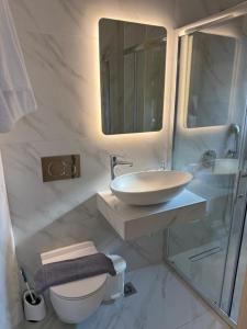 a white bathroom with a sink and a toilet at Marinas view apartment in Limenas +19 photos