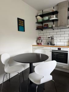 a kitchen with a black table and white chairs at G6 Apartment in Grundarfjordur +5 photos