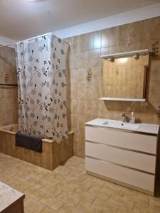 a bathroom with a sink and a shower with a shower curtain at Lakeview apartment in Pergine Valsugana