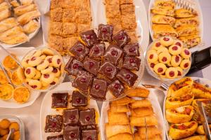 a table filled with different types of pastries and desserts at Palhoça Hotel in Canindé
