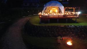 a lit up igloo with lights in a field at night at MB Glamp in Międzybrodzie Bialskie