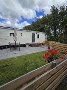 a backyard with a house and a table and a patio at Prachtig chalet DE WADLOPER in Westerland