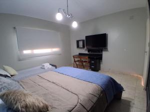 a bedroom with a bed and a flat screen tv at Dos Lapachos in San Fernando del Valle de Catamarca