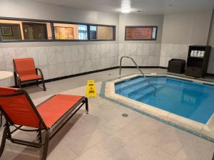 a pool in a room with a chair and a table and a chair at Wingate by Wyndham Harrisburg Near Hershey in Harrisburg