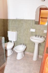 a bathroom with a toilet and a sink at Hotel El Jardin Dante in Tilcara