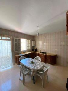 a kitchen with a table and chairs in a room at Vacation home in Kelibia