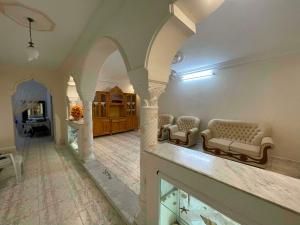 a living room with couches and a room with a fireplace at Vacation home in Kelibia