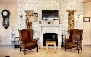 a living room with two chairs and a fireplace at Alaçatı Beach Resort in Yumru