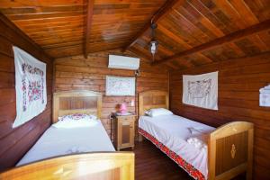 a bedroom with two beds in a wooden cabin at Rankine Kolibe in Kladovo