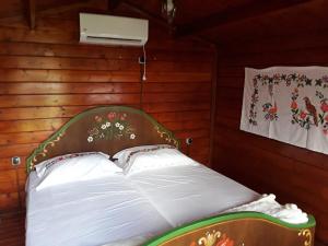 a bed in a room with wooden walls at Rankine Kolibe in Kladovo