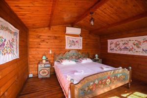 a bedroom with a bed in a wooden room at Rankine Kolibe in Kladovo +5 photos
