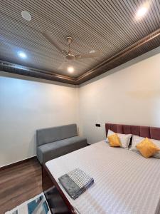 a room with a bed and a couch and a ceiling at Rodali stay in Dibrugarh