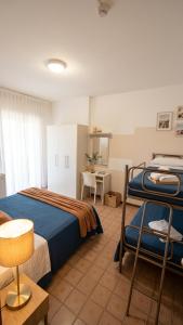 a hotel room with two beds and a table at B&B - Meuble' - Hotel " CORDIALE " in Misano Adriatico